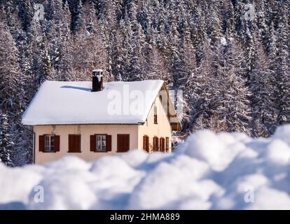 Cinuos-Chel, Svizzera - 3 febbraio 2022: Casa generica nel bosco in mezzo a un paesaggio invernale innevato in Engadina, Svizzera Foto Stock