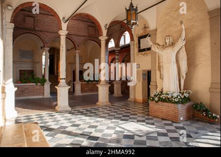 Oratorio Santa Caterina a Fontebranda. Il chiostro interno, con una statua del santo. Foto Stock