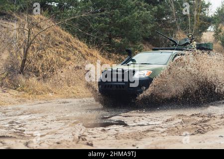 Gli ingranaggi del carrello di pattuglia per servizi pesanti si sporcano nella pozza di fango . Foto di alta qualità Foto Stock