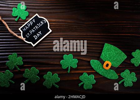 Etichetta di benvenuto shamrock a tre foglie fatta a mano e cappello d'edera su sfondo di legno Foto Stock