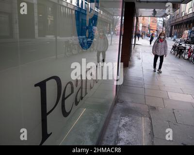 Pendolari che passano accanto alla sede centrale della società di formazione Pearson nel centro di Londra, Pearson plc è un'azienda britannica di editoria e formazione con uffici a Londra. Foto Stock
