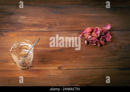 Sbucciate di fondo fresco con una tazza di profiterolo da dessert vuota con cucchiaio su un tavolo di legno marrone dopo il pasto, pelle di lichi o litchi chinensis f Foto Stock