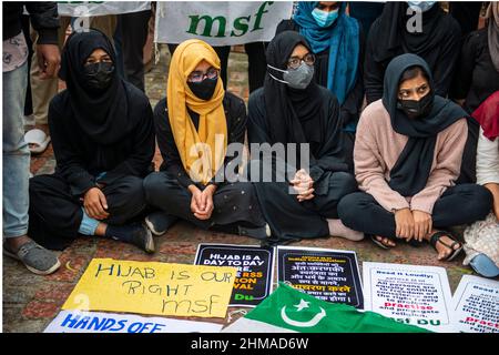 New Delhi, India. 08th Feb 2022. Un gruppo di ragazze musulmane in hijab e membri della Federazione musulmana degli studenti 'Delhi University si siedono sul terreno accanto ai loro cartelli durante la manifestazione.studenti musulmani che protestano contro Hijab Ban in High School e college di Karnataka (Uno stato dell'India). La polemica è iniziata nel gennaio 2022, quando alcuni studenti nei college dello stato di Karnataka hanno iniziato a indossare hijab. Credit: SOPA Images Limited/Alamy Live News Foto Stock