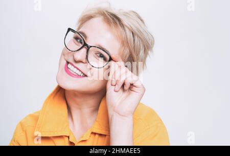 Negozio di ottica. Occhiali alla moda. Donna sorridente bionda indossare occhiali da vicino. Moda per gli occhi. Aggiungi accessorio smart. Ragazza alla moda con Foto Stock