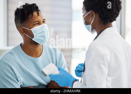 Abbiamo bisogno di discutere la vostra trmperatura. Shot di un medico che mostra al paziente la sua temperatura. Foto Stock