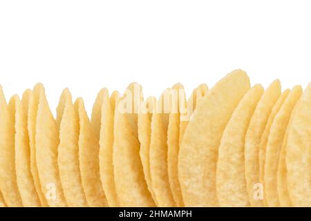 Un mucchio di patatine è allineato in una fila. Isolato su sfondo bianco. Primo piano. Foto Stock