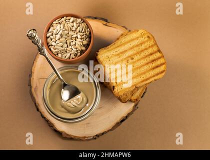 Pane tostato spalmato burro biologico di girasole. Un delizioso, cremoso e salato. Alternativa ipoallergenica al burro di arachidi. Foto Stock