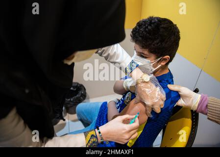 Teheran, Iran. 05th Feb 2022. Un ragazzo iraniano che ha 11 anni e indossa una maschera protettiva per il viso riceve una dose del vaccino cinese Sinopharm new coronavirus disease (COVID-19) nel complesso commerciale di IranMall a nord-ovest di Teheran. (Foto di Sobhan Farajvan/Pacific Press/Sipa USA) Credit: Sipa USA/Alamy Live News Foto Stock