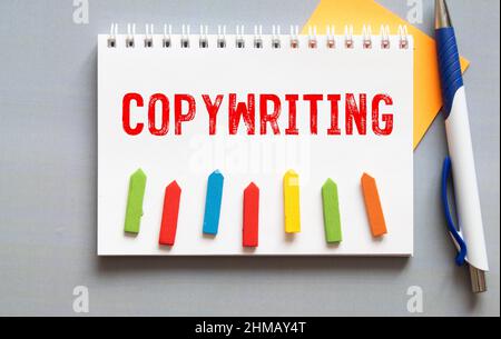 Copywriting parola su una scheda bianca accanto a un notebook e una penna nera sul tavolo Foto Stock