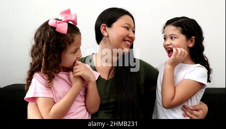 Madre asiatica che dice buone notizie alle figlie, mamma giapponese con razza mista le bambine amore Foto Stock