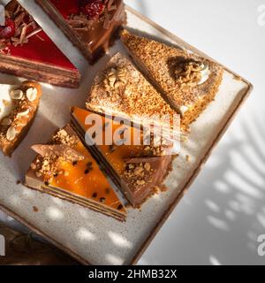 Assortimento di pezzi di torta su piatto, spazio copia. Diverse fette di deliziosi dessert, menu del ristorante concetto, vista dall'alto Foto Stock