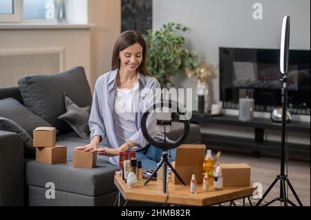 Sorridente allenatore di bellezza giovane che ha un webinar Foto Stock