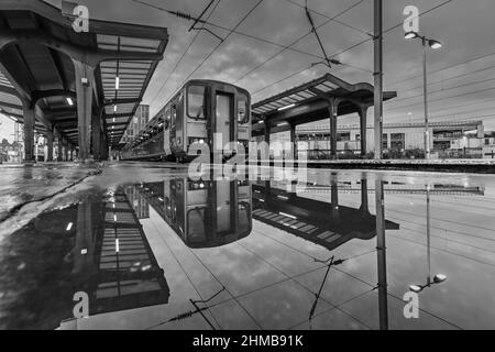 2 Northern Rail classe 153 treni sprinter riflesso in un pudddle alla stazione ferroviaria di Preston Foto Stock