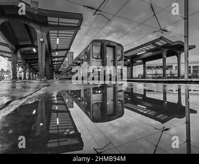 2 Northern Rail classe 153 treni sprinter riflesso in un pudddle alla stazione ferroviaria di Preston Foto Stock