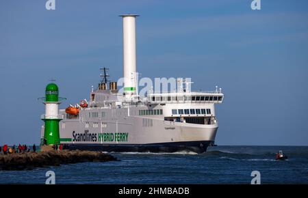 05 febbraio 2022, Meclemburgo-Pomerania occidentale, Warnemünde: Numerose passeggini guardano il traghetto Scandlines 'Copenhagen' entrare nel canale marittimo di Rostock dal Mile. Il clima invernale soleggiato attrae turisti e visitatori giornalieri sulla costa di Mecklenburg-Vorpommern. Foto: Jens Büttner/dpa-Zentralbild/ZB Foto Stock