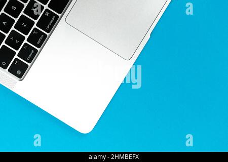 Notebook piatto sfondo blu. Piano di lavoro per ufficio, concetto di progettazione minimo. Vista dall'alto, spazio di copia Foto Stock