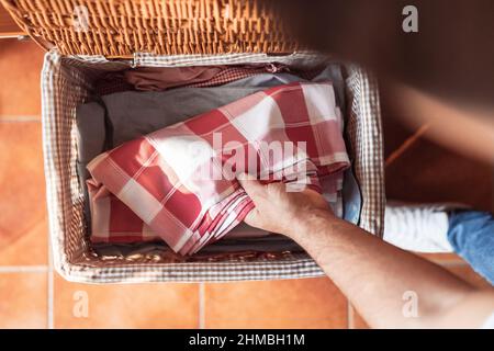 zenith colpo di mano di un uomo che raccoglie una tovaglia per stirare. Foto Stock