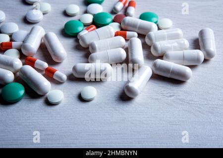 pillole mediche multicolore sono sparse sul primo piano del tavolo Foto Stock