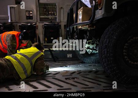 Jaionka, Polonia. 08th Feb 2022. I professionisti del porto aereo e della manutenzione dell'Aeronautica militare degli Stati Uniti assegnati al controllo dell'Ala 521st delle operazioni di mobilità aerea sotto un Humvee dell'Esercito degli Stati Uniti per le catene di mantenimento all'aeroporto di Rzeszów-Jasionka, Polonia, il 7 febbraio 2022. I membri dell'AMOW del 521st si sono schierati per sostenere l'Ala 435th Air Ground Operations in Polonia per preparare l'aeroporto all'arrivo delle forze dell'esercito degli Stati Uniti. Foto di Senior Airman Taylor Slater/U.S. Air Force/UPI Credit: UPI/Alamy Live News Foto Stock