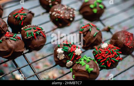 Le palle di torta di cioccolato sono decorate in colorate spolverette per i vassoi dolci di natale Foto Stock