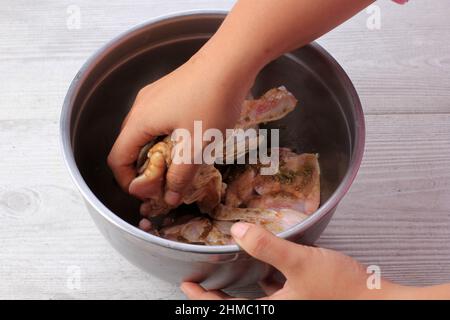 Strofinare le spezie asciutte sul bastone di pollo, facendo il pollo arrosto procedura di cottura passo per passo in cucina Foto Stock