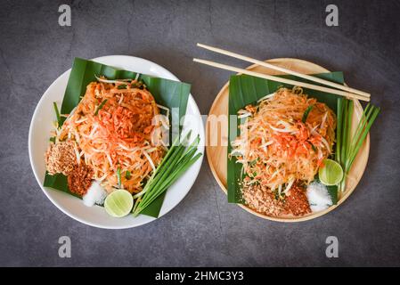 Noodle Pad Tailandesi in padella servito al tavolo da pranzo, noodle Tailandesi fritto in stile Tailandese con gamberi di fagiolo e guarnire il peperoncino di arachidi Foto Stock