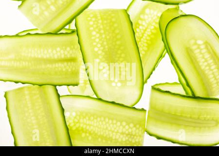 Bellissime fette di cetriolo fresche e trasparenti su sfondo bianco Foto Stock