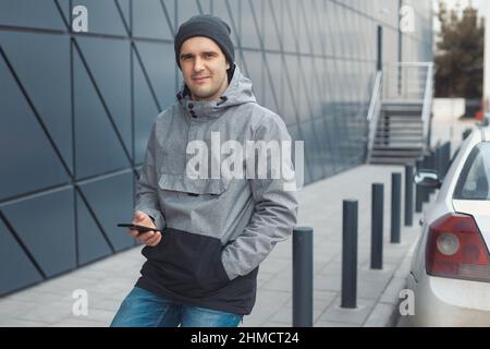 Ritratto Street style di bel 30-35 anni uomo all'aperto vicino al muro Foto Stock