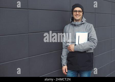 Primo piano ritratto di bel 30-35 anni uomo all'aperto in piedi vicino al muro Foto Stock