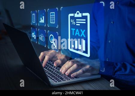 Persona che compila il modulo fiscale sul computer. Riduzioni, detrazioni ed esenzioni. Contabile e consulenza finanziaria per ridurre l'aliquota fiscale. Foto Stock