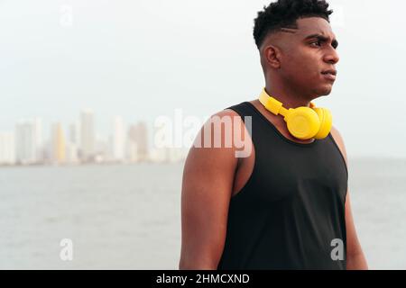African Man in abbigliamento sportivo con cuffie sulla strada per la palestra Foto Stock