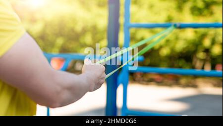 Uomo che si sta allenando con la banda di resistenza Foto Stock