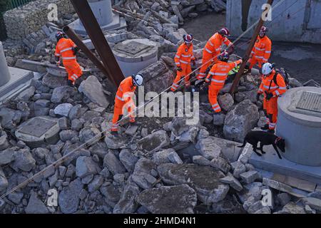 I funzionari del servizio antincendio e di soccorso Tyne and Wear si allenano su una nuova struttura di addestramento all'avanguardia che aiuterà i vigili del fuoco a salvare le vittime degli edifici in crisi presso la sede centrale del servizio, a Barmston Mere, Washington, Sunderland. Merlin, il cane URBAN Search and Rescue (USAR), ha anche contribuito a evidenziare come il K9 appositamente addestrato può aiutare a localizzare le persone nell'edificio collassato. Data foto: Mercoledì 9 febbraio 2022. Foto Stock