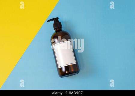 Svuotare il flacone di sapone o shampoo in vetro ambrato su sfondo isolato. Cura della pelle o concetto di capelli con cosmetici naturali. Foto Stock