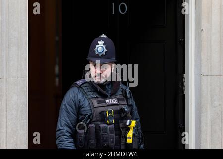 Londra, Regno Unito. 9 febbraio 2022. Un poliziotto è visto alla porta di 10 Downing Street. Il primo Ministro è stato sottoposto a pressioni da interrogazioni di parlamentari relativi a partiti tenuti a Downing Street dal 20 maggio 2020, in un momento in cui le restrizioni di blocco del Regno Unito vietano gli incontri sociali. La polizia metropolitana sta indagando sulle parti sulla base di informazioni fornite dal team di inchiesta del Gabinetto, guidato dal funzionario sue Gray, il cui rapporto, molto redatto, è stato pubblicato di recente. Credit: Stephen Chung / Alamy Live News Foto Stock