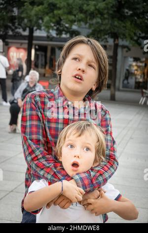 Ragazzo abbracciando da dietro il fratello piccolo sul sentiero Foto Stock