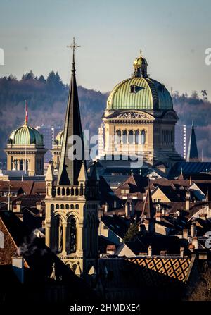 Il "Berner Münster", l'edificio centrale del centro storico di Berna in Svizzera, con camino dagli edifici della città in primo piano Foto Stock