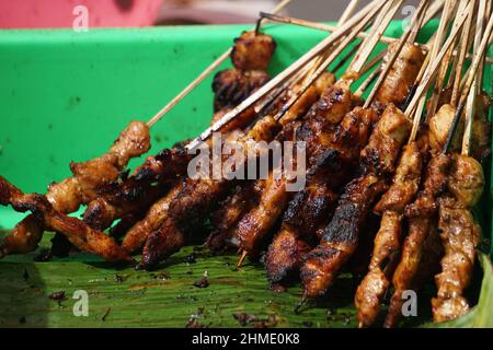 Sate (spiedo) sulla padella. Il Sate è uno dei piatti tradizionali indonesiani serviti con salsa di arachidi Foto Stock