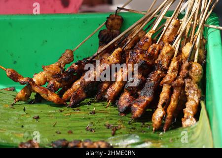 Sate (spiedo) sulla padella. Il Sate è uno dei piatti tradizionali indonesiani serviti con salsa di arachidi Foto Stock