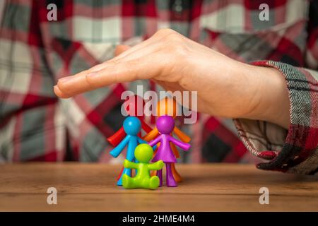 Concetto di assicurazione di famiglia con una figurine di famiglia colorata coperta a mano Foto Stock