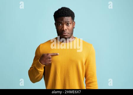 Confuso giovane nero che punta a se stesso Foto Stock