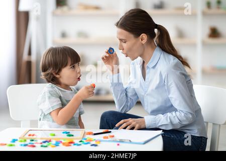 Terapista del parlato femminile che cura i problemi e gli impedimenti del bambino. O con un tutor privato Foto Stock