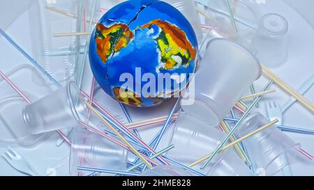 globo vicino a tazze di plastica e rifiuti su bianco Foto Stock