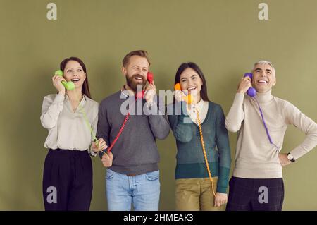 Le persone sorridenti parlano sul telefono fisso con il servizio clienti Foto Stock