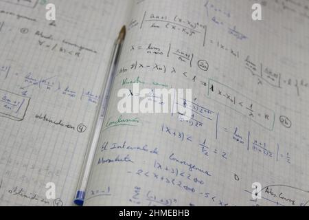 Immagine di alcuni fogli con esercizi risolti di limiti matematici su cui è presente una penna blu usata Foto Stock