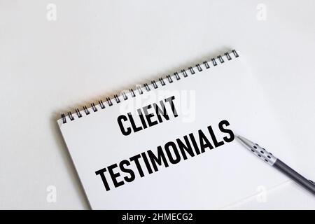 Testimonianze dei clienti - testo scritto a mano in blocco note sul tavolo Foto Stock