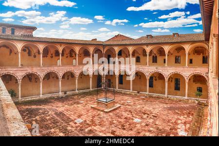 Vista panoramica con lo scenografico cortile nel convento della Basilica di San Francesco, Assisi, Italia. Del Patrimonio mondiale UNESCO dal 2000 Foto Stock