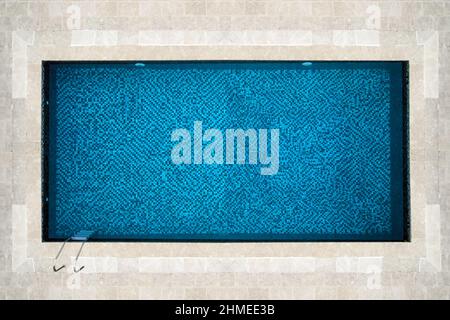 vista dall'alto di una splendida piscina rettangolare idilliaca con mosaico blu sul fondo Foto Stock