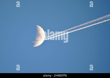 Un aereo che vola di fronte su una mezzaluna 1 di 4 colpi Foto Stock