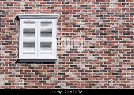 Finestra rettangolare in mattoni rossi e bianco con chiusura Foto Stock